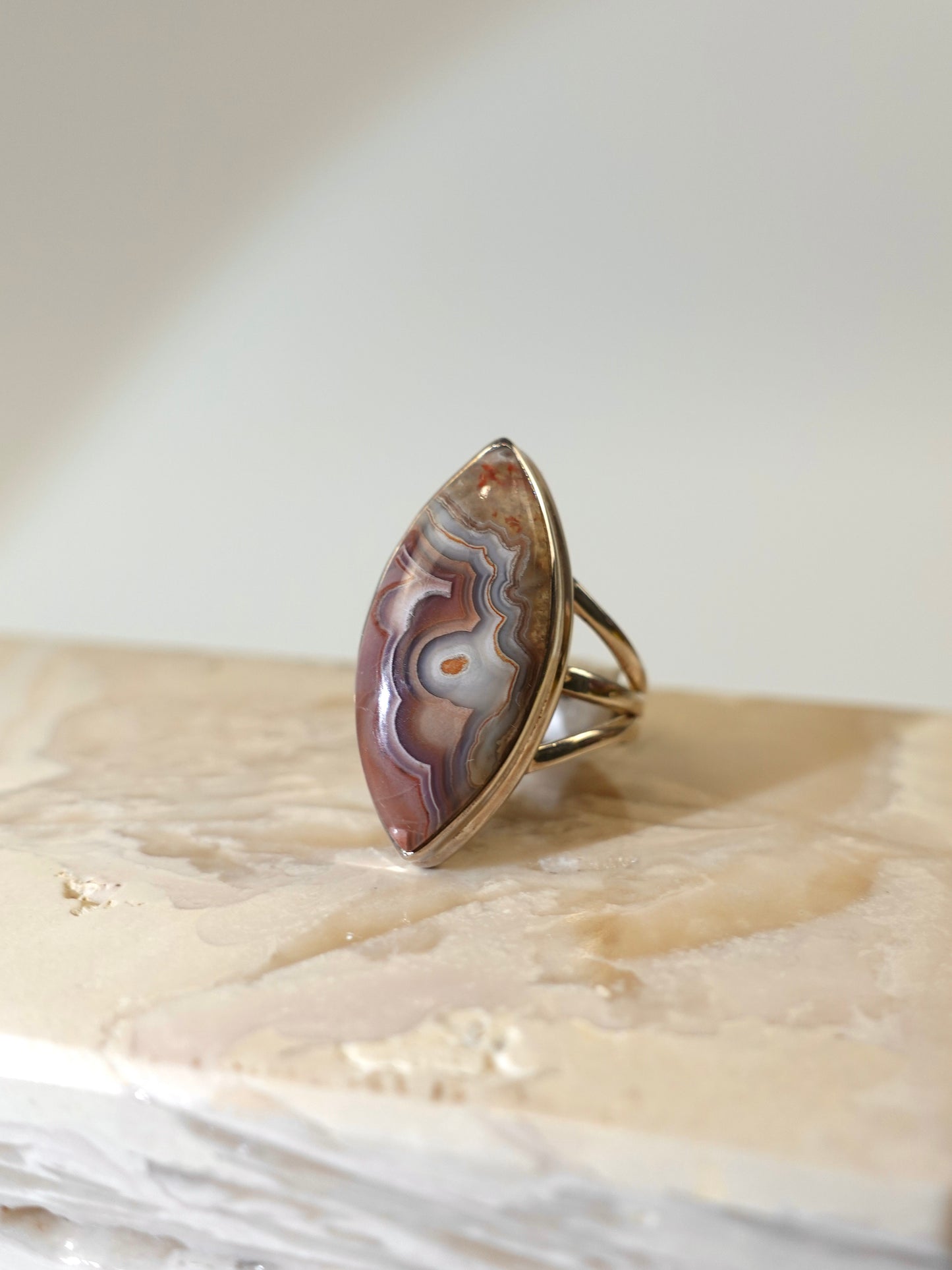 Laguna Agate Marquise ring on travertine display with white background