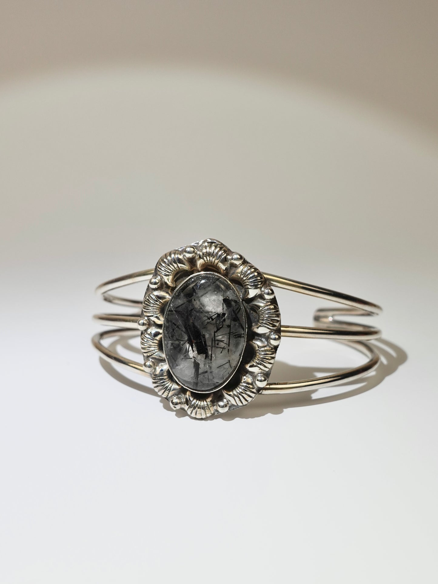 Tourmalinated Quartz cuff bracelet with floral broach design on white background