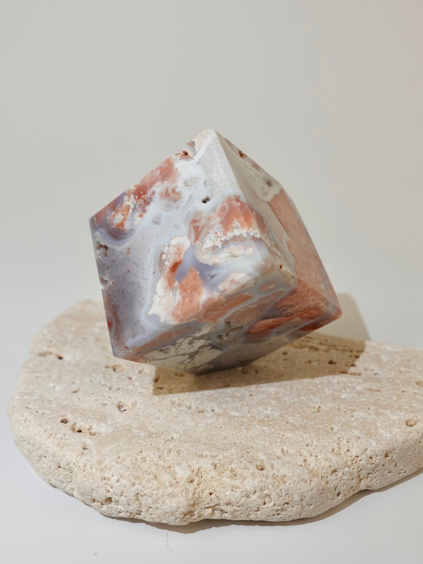 Pink Agate Floating Cube Option B on travertine display and white background