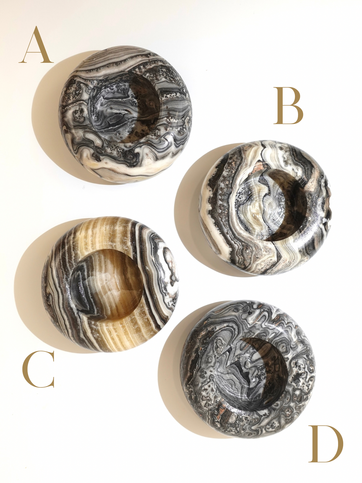 Four zebra calcite candle holders labeled A, B, C , and D on a white background