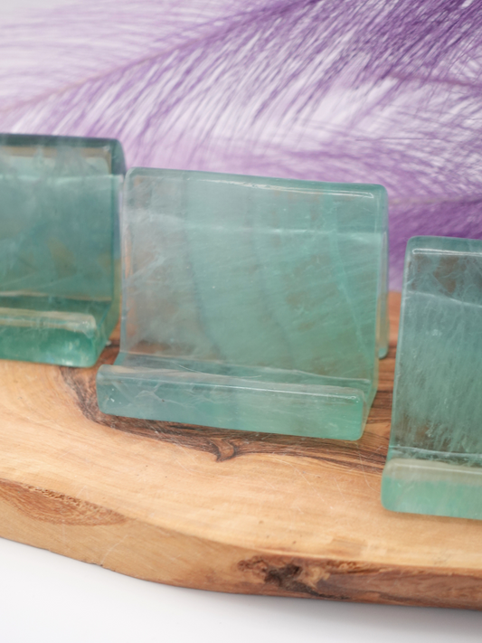 Three fluorite phone holders on wooden display stand