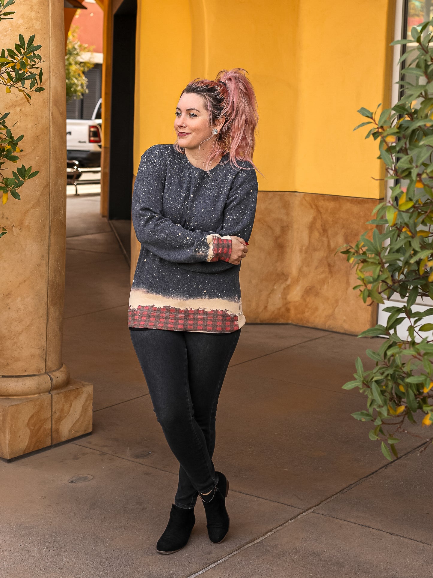 Grey crewneck with bleach patterns and buffalo plaid across the bottom.