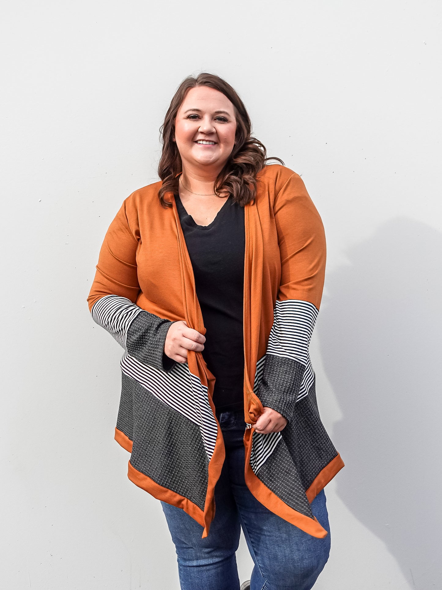 Tan colored cardigan with colored blocked details in stripes and grey