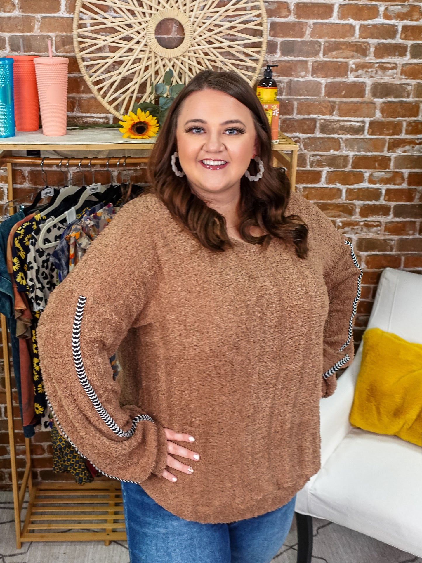 Brown sweater with black and white details down the sleeves.