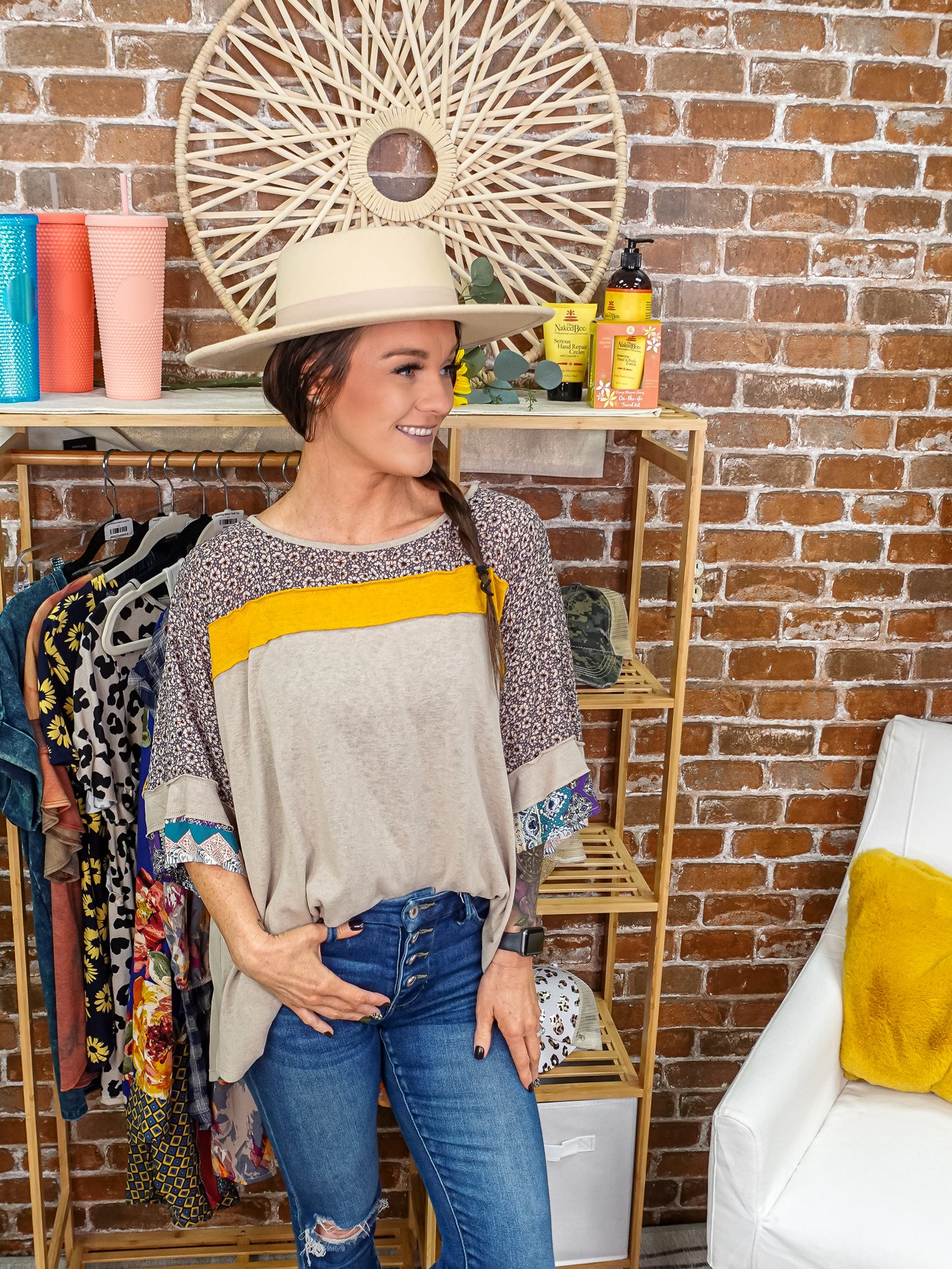 Tan colored top with mix patterns tucked into denim