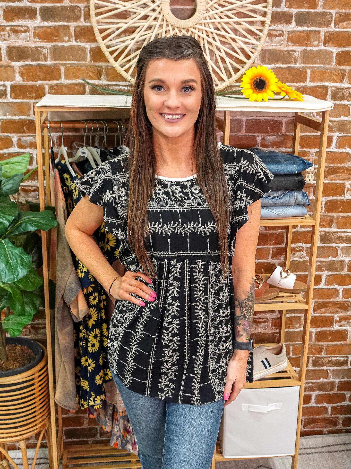 Black, short sleeve, babydoll top with embroidered patterns throughout..
