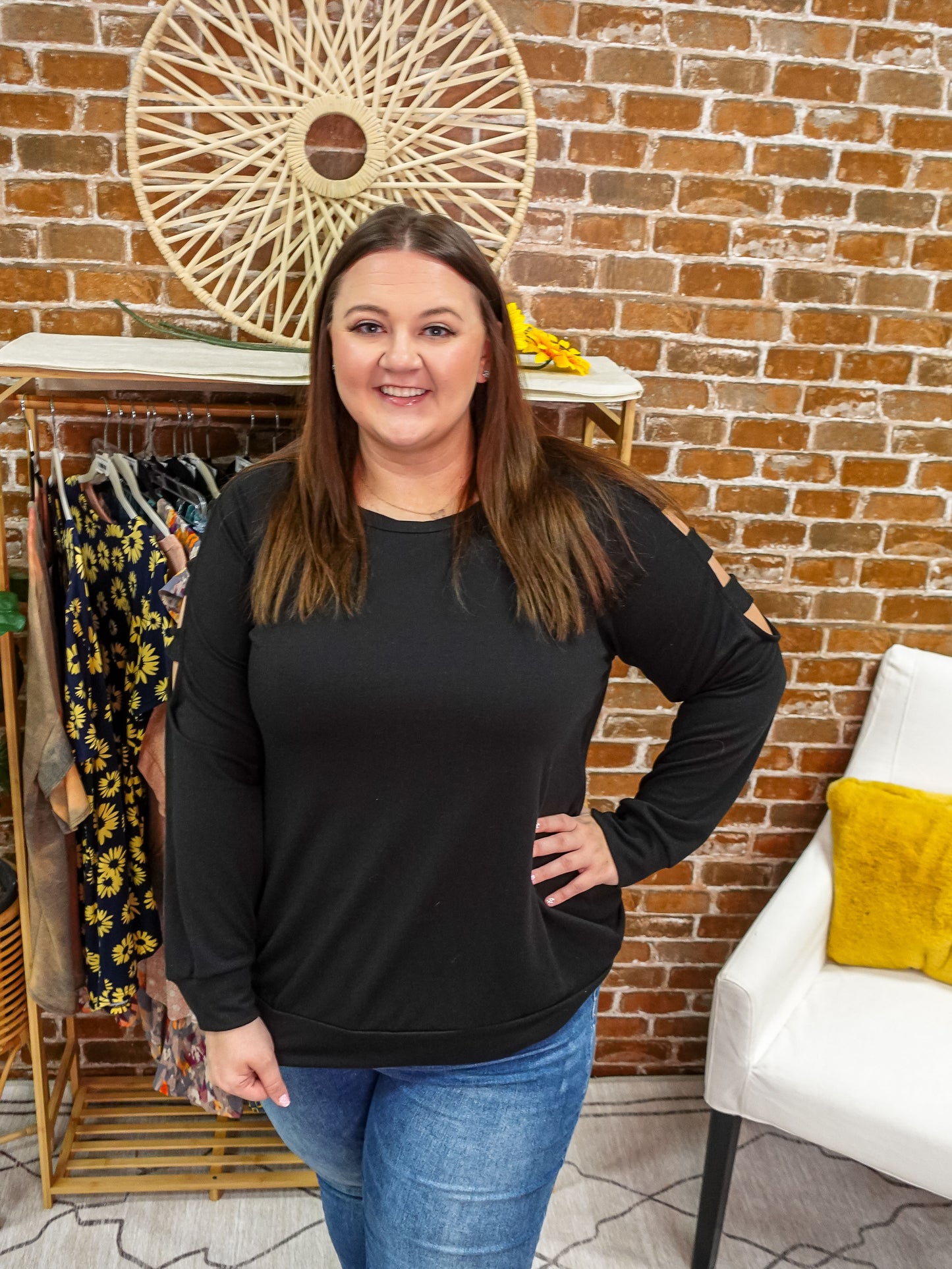 Cold shoulder cut out long sleeve top with rounded neckline in black.