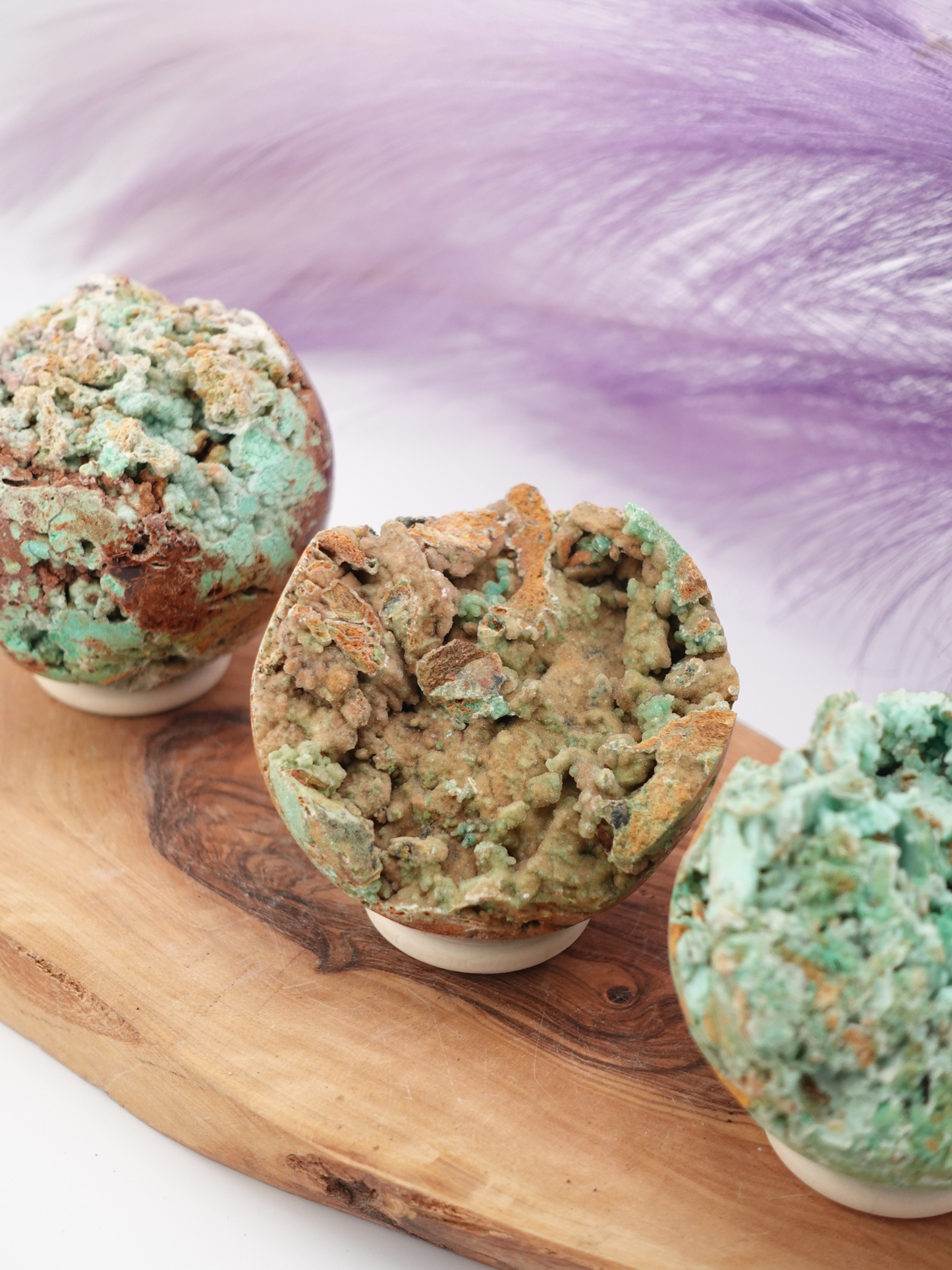 Three Smithsonite spheres displayed on wooden stand