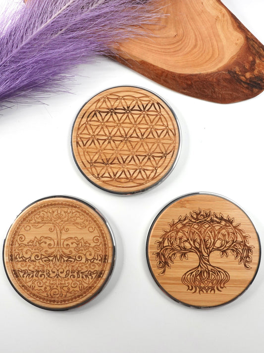 Three silver and wooden design wireless chargers on white background
