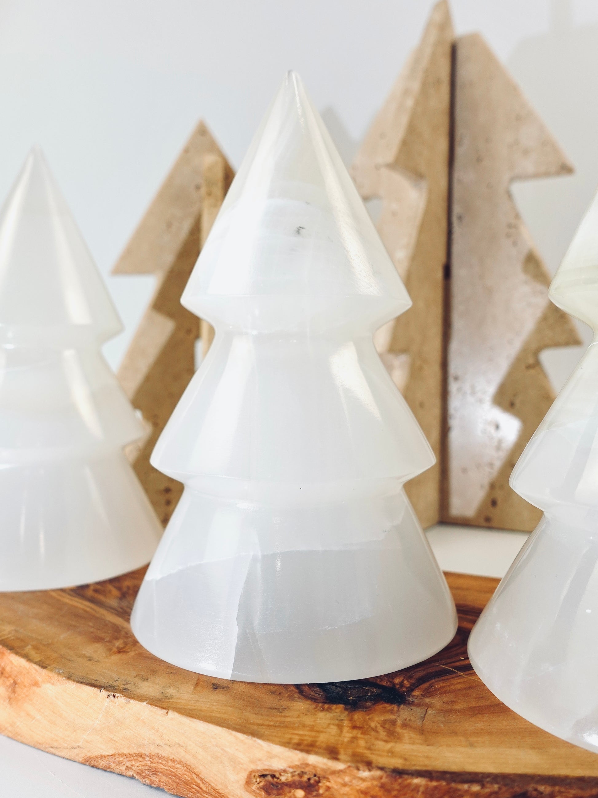 White tree-shaped objects on a wooden surface with a neutral background