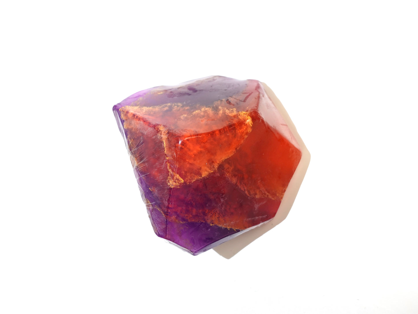 Polished crystal inspired soap with purple and orange colors on a white background