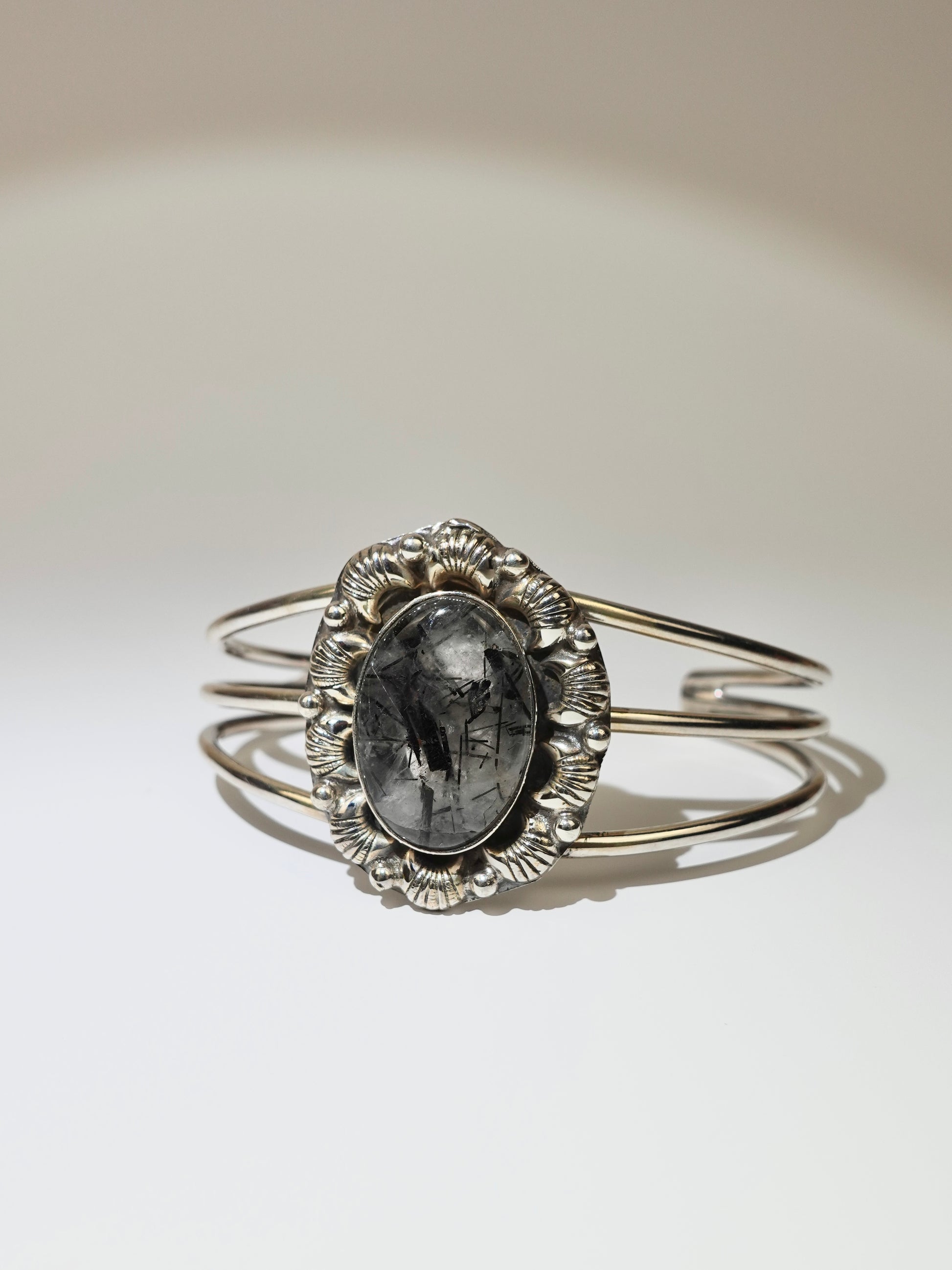 Tourmalinated Quartz cuff bracelet with floral broach design on white background