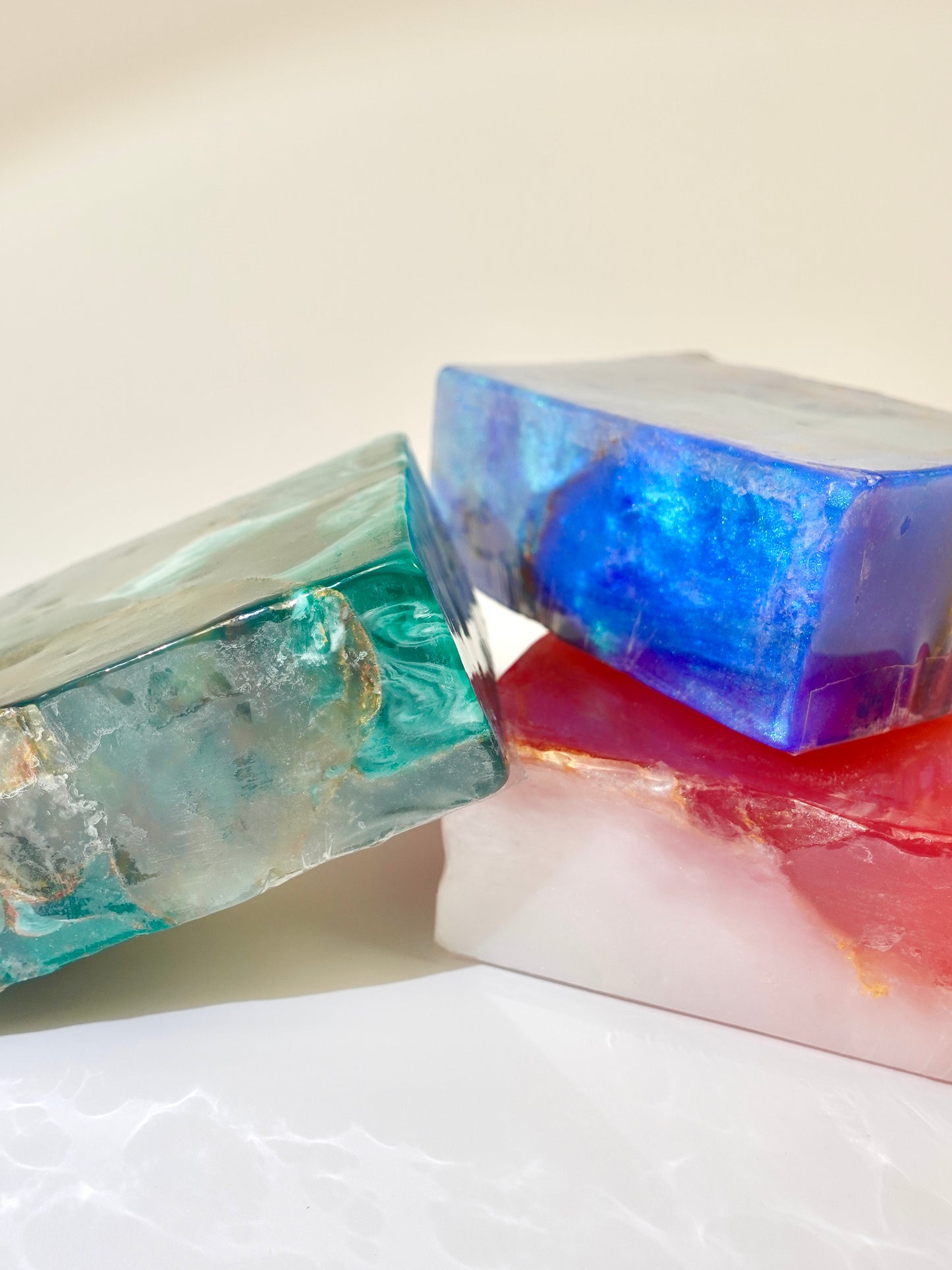 Three colorful soap bars on a light background