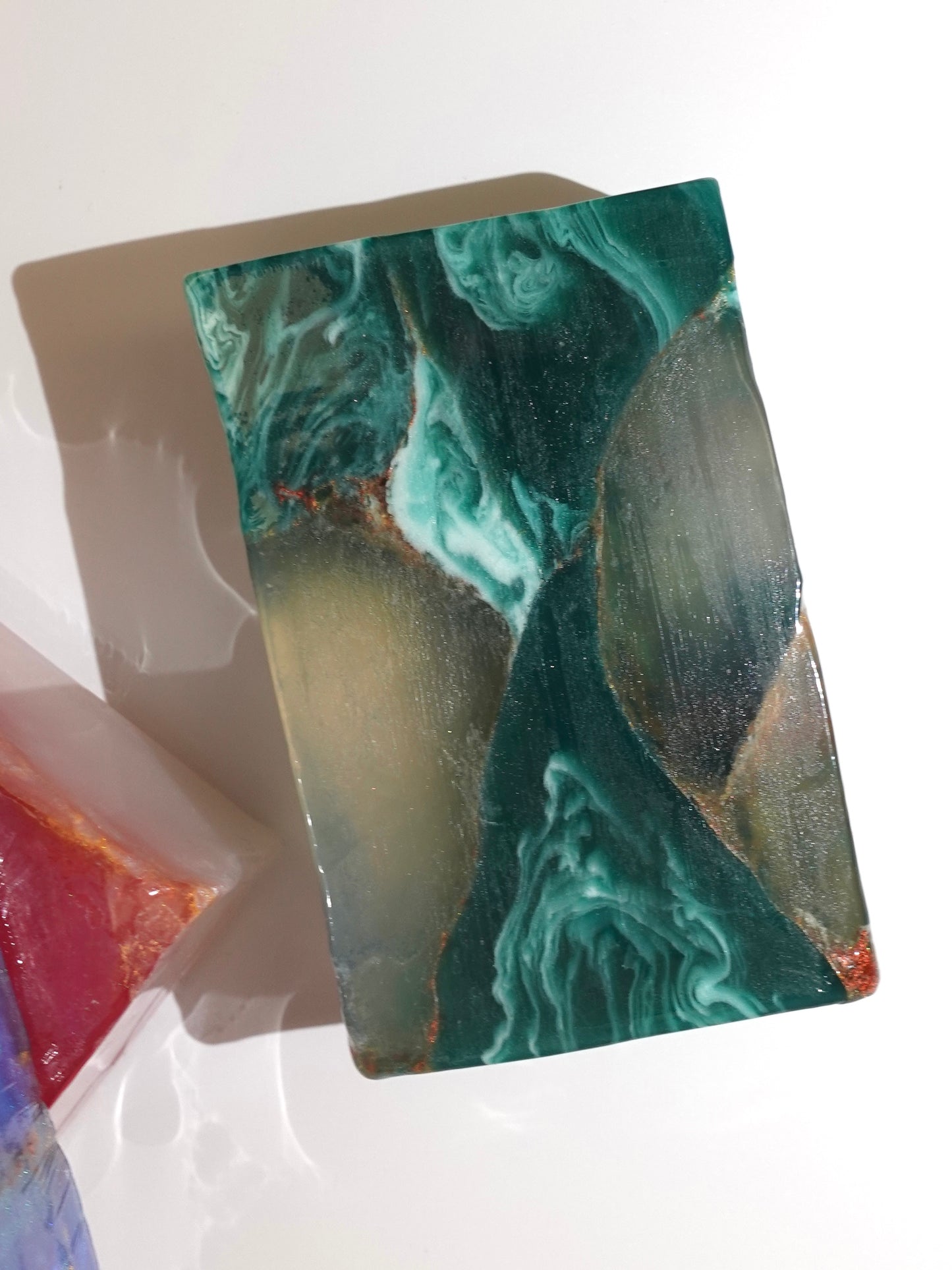 Marbled soap bar with green and brown patterns on a white background