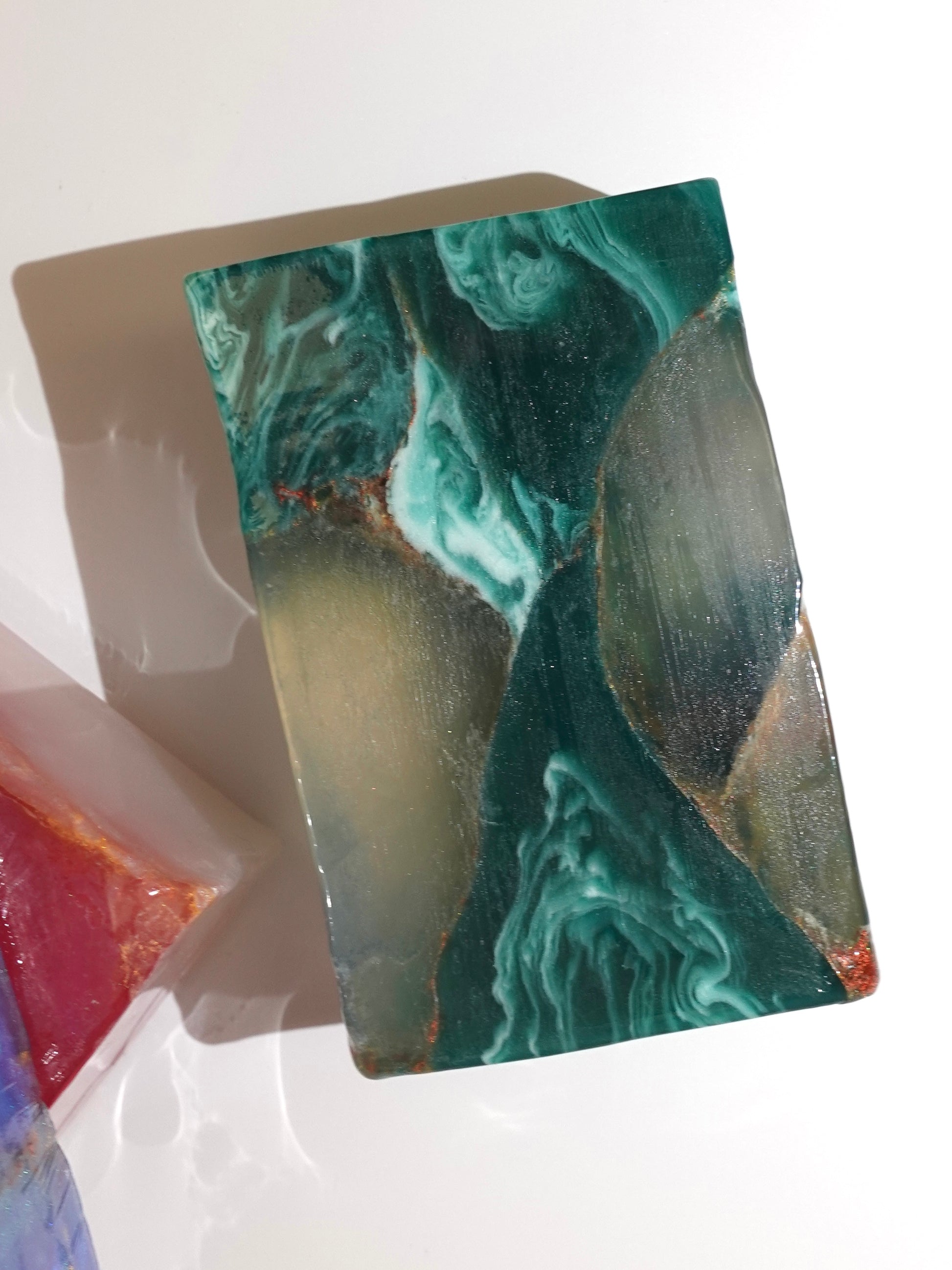 Marbled soap bar with green and brown patterns on a white background