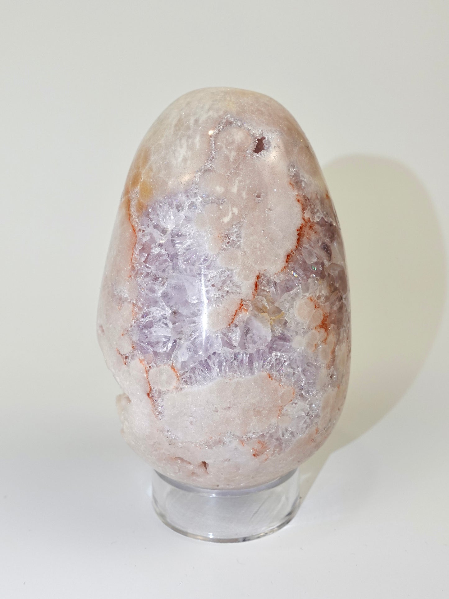 Pink amethyst egg on white background