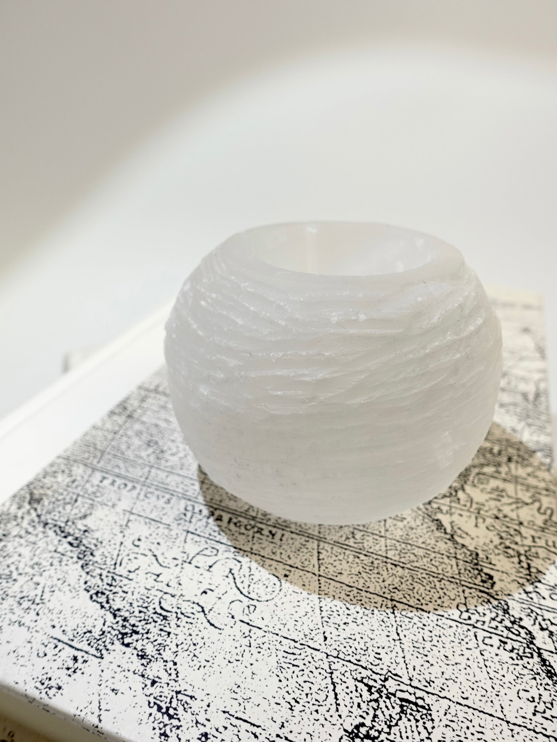 selenite candle holder on white and black display