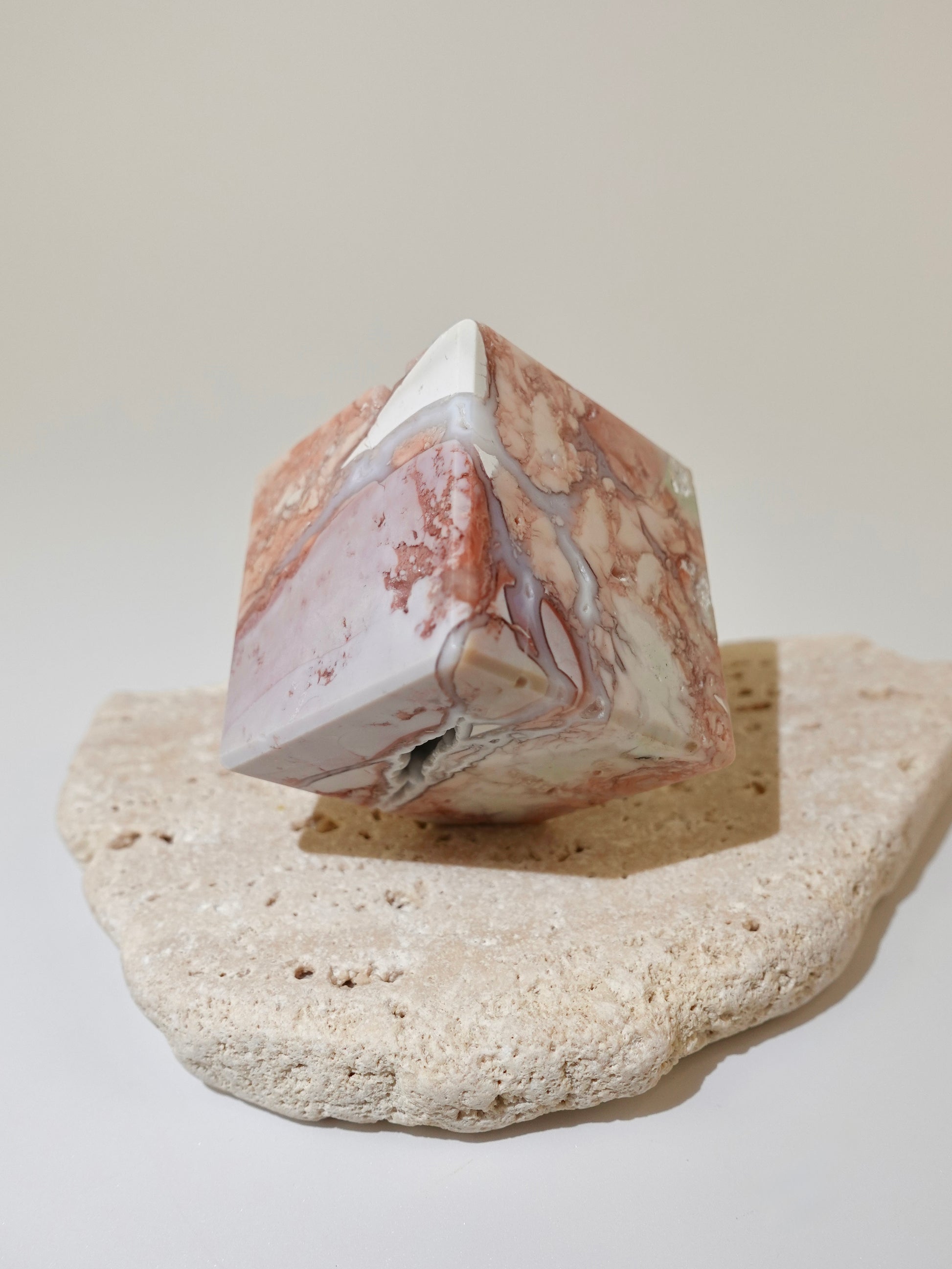 Pink Agate Floating Cube Option C on travertine display and white background