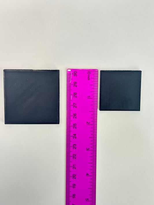 Both sizes of black specimen stands displayed next to a ruler for size comparison