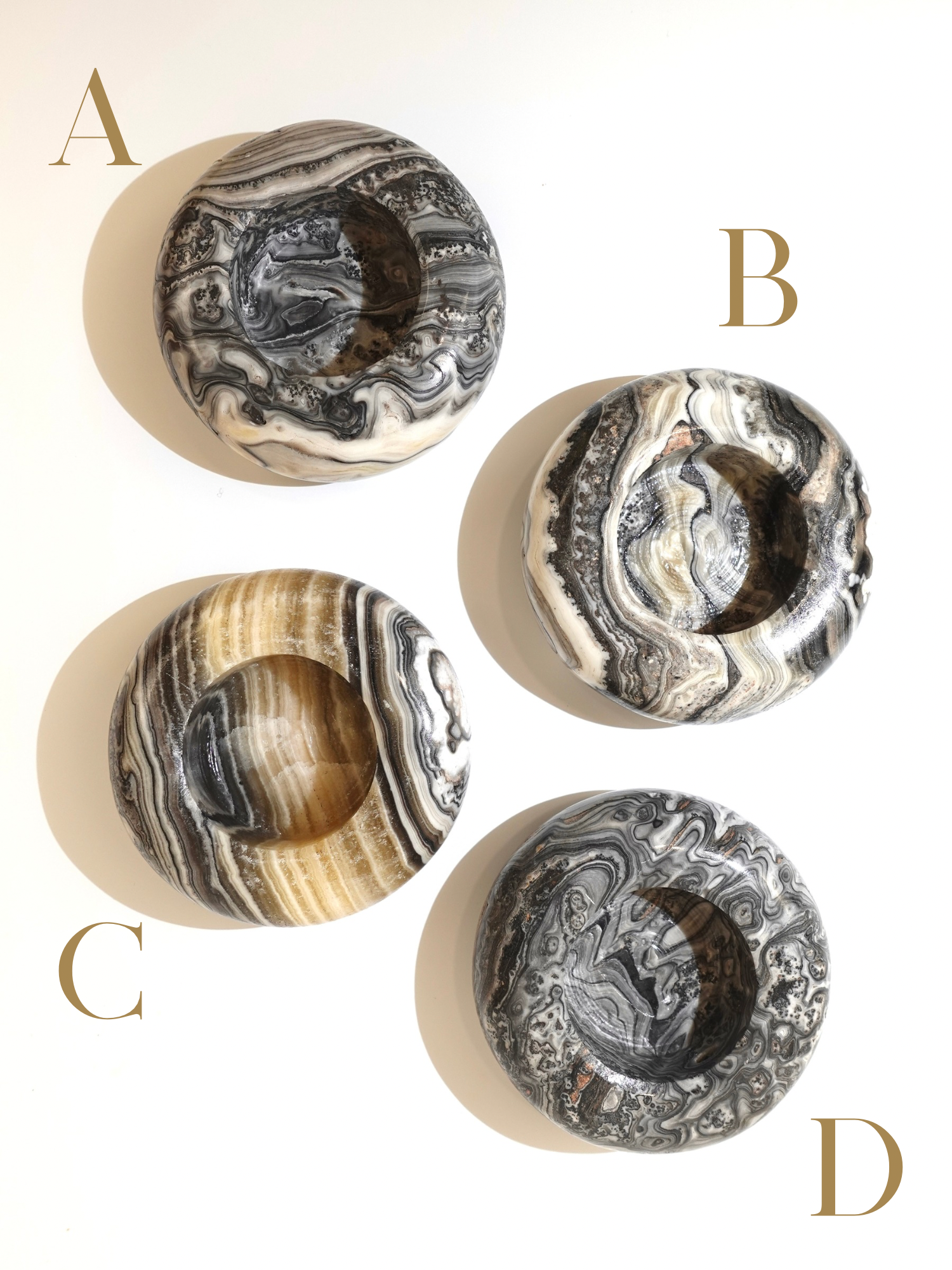 Four zebra calcite candle holders labeled A, B, C , and D on a white background