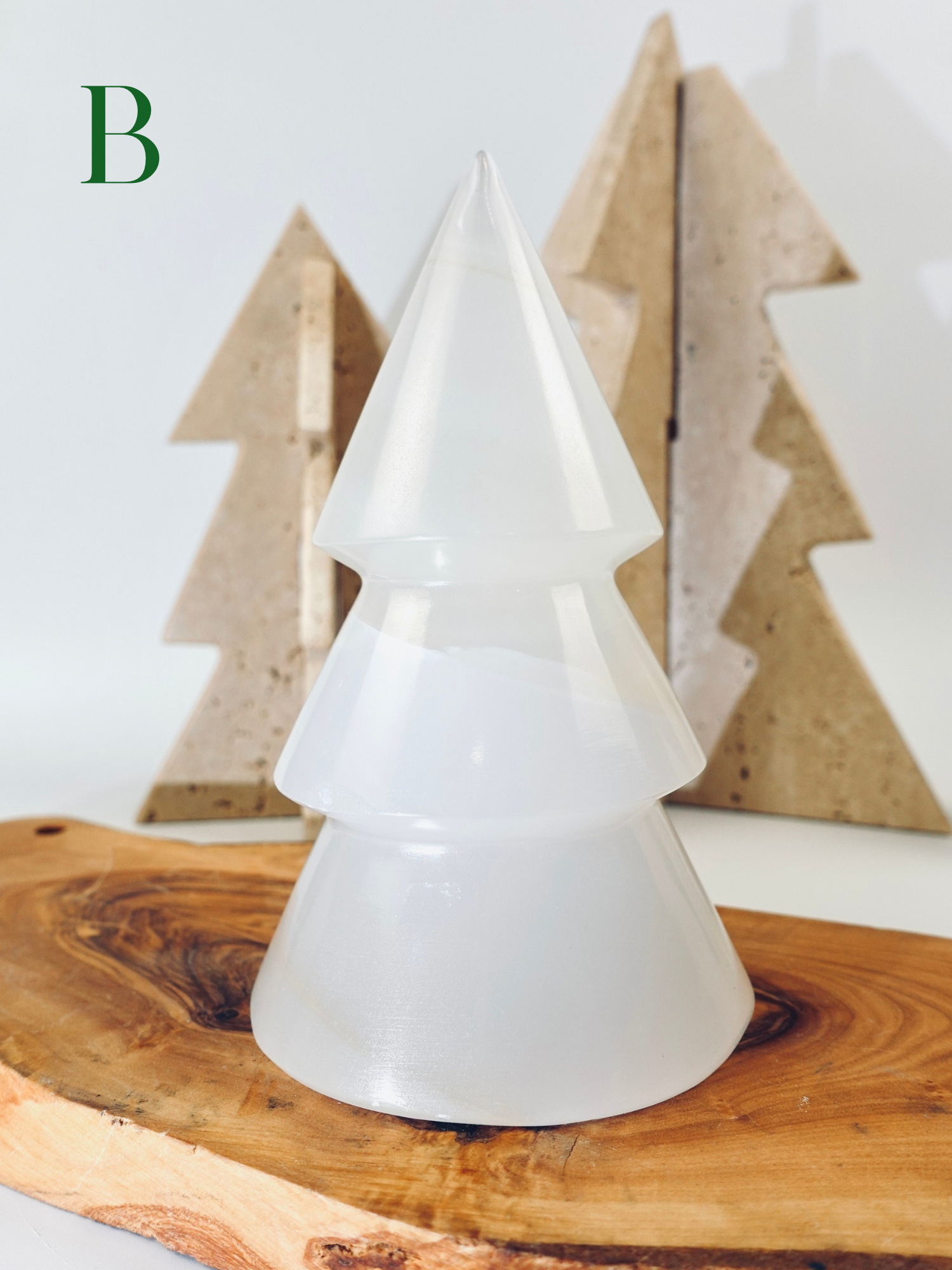 White tree-shaped lamp on a wooden surface with wooden trees in the background
