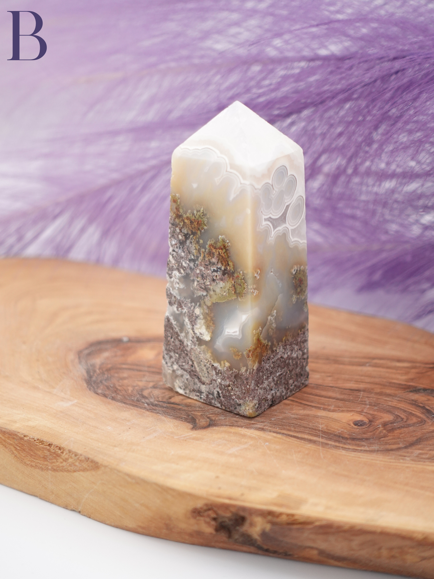 Scenic moss agate tower option B on wooden display stand