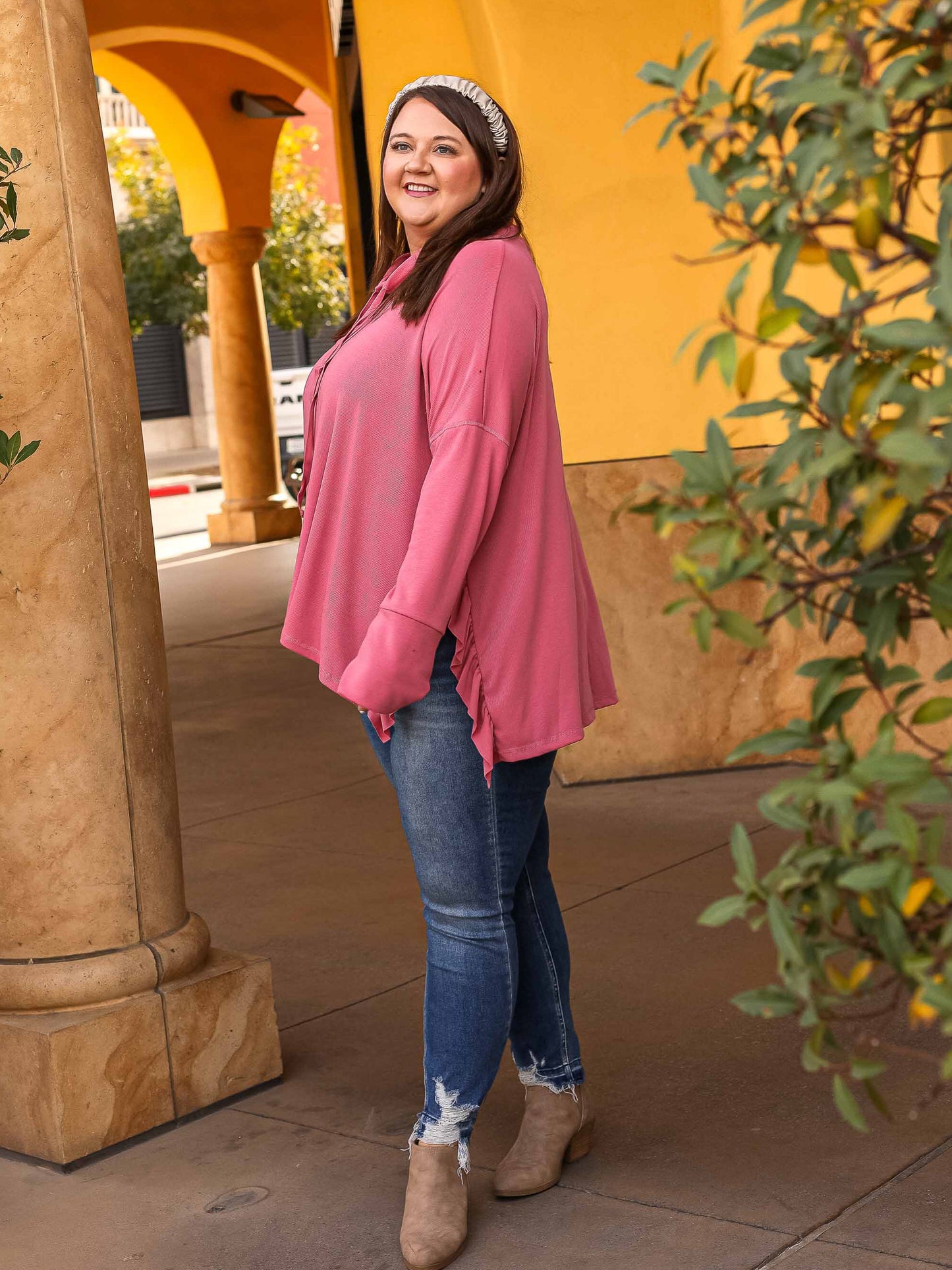 Pink ruffled top styled with jeans and booties