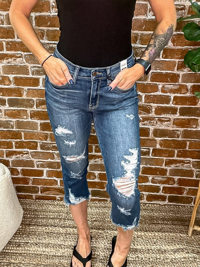 Front view of blue jean distressed capris