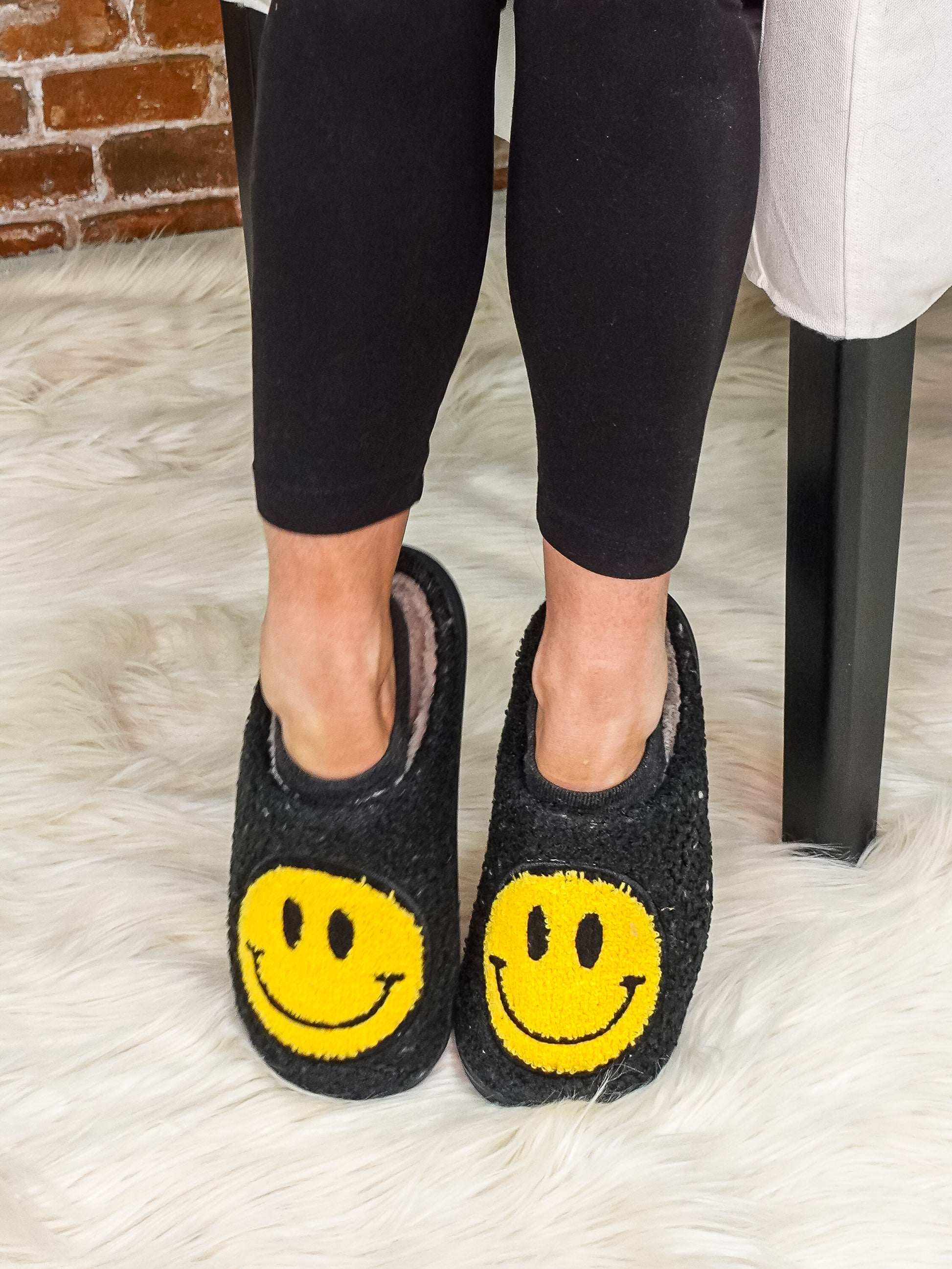 Smily face slippers in black with yellow smily.