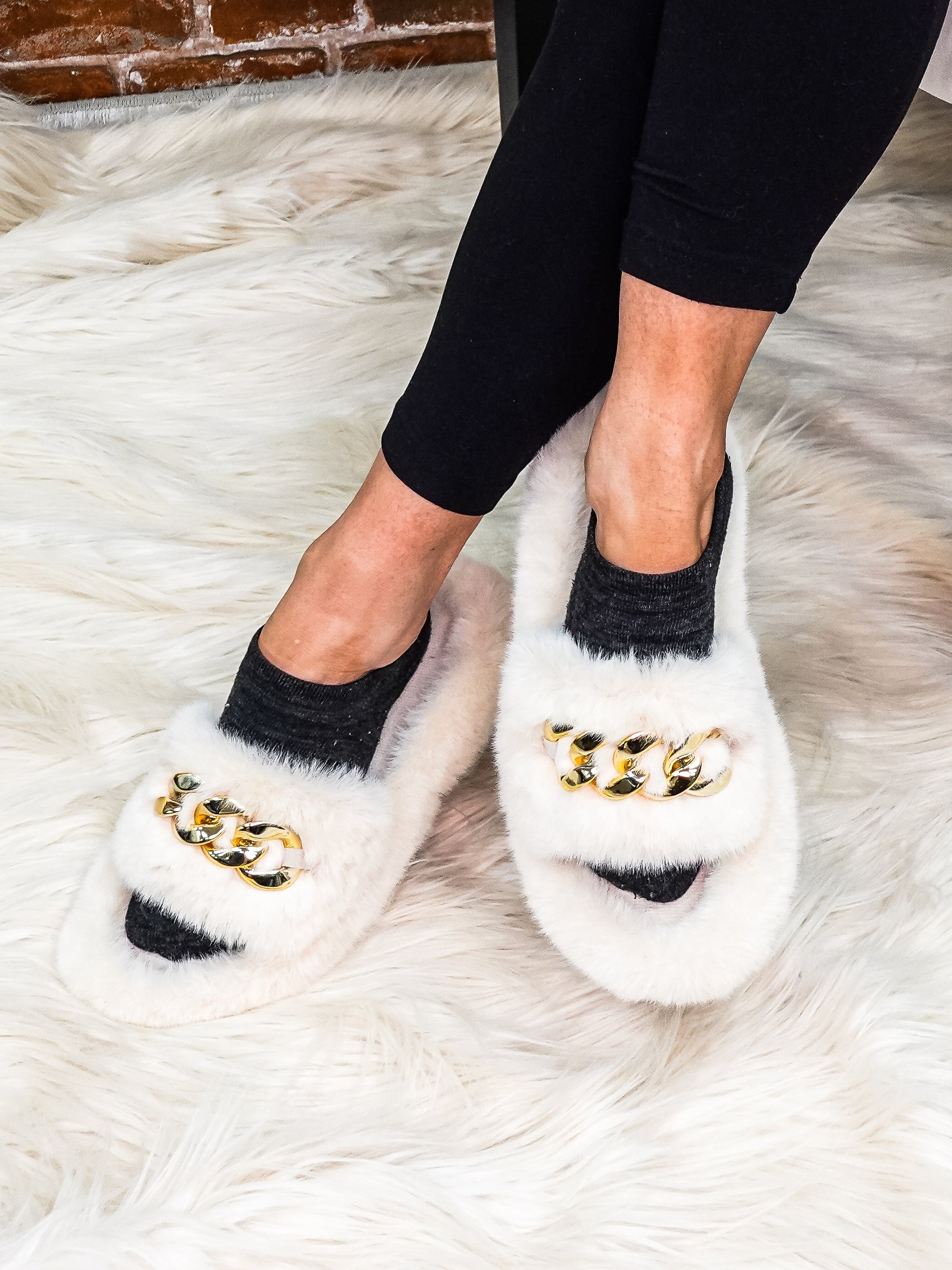Ivory faux fur slippers with gold chain links.