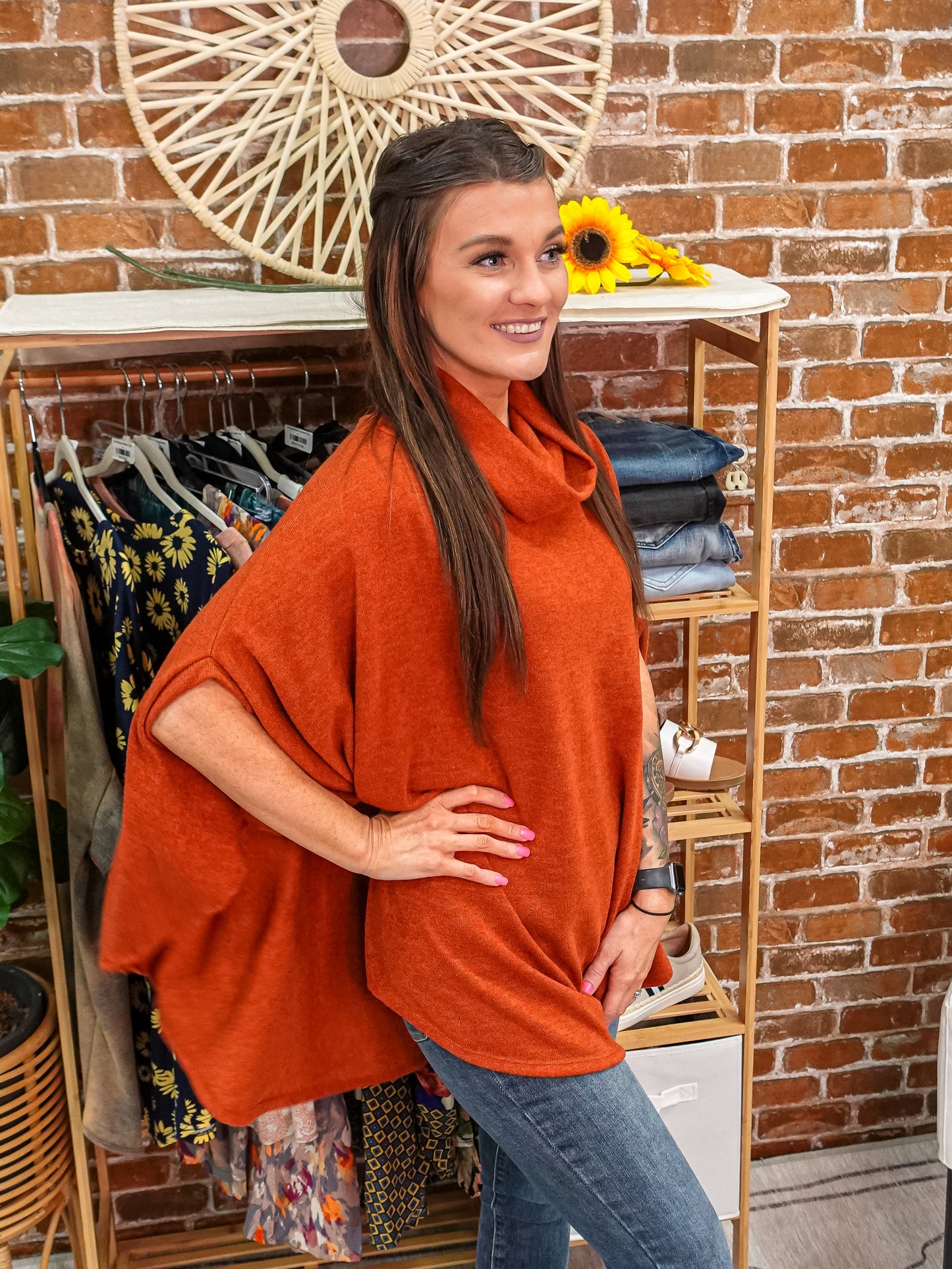 Side view: orange poncho with turtle neck and side slit. 