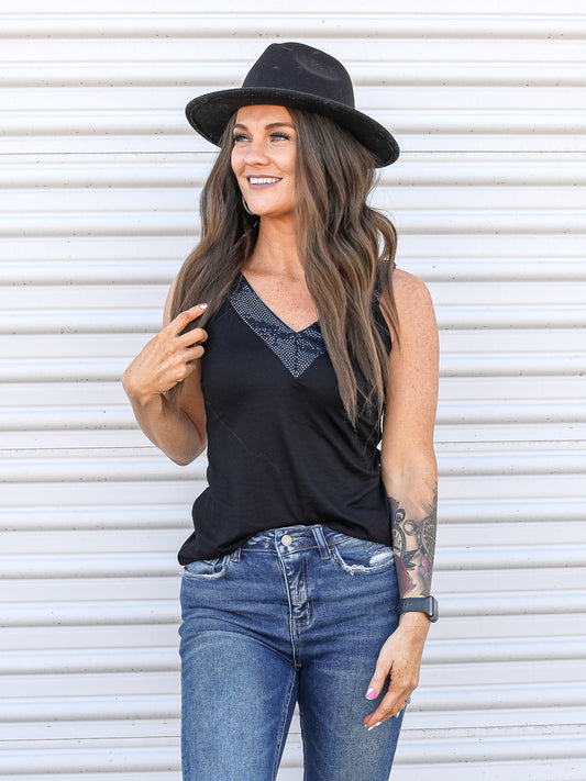 Black tank with sequin v-neck line tucked into jeans