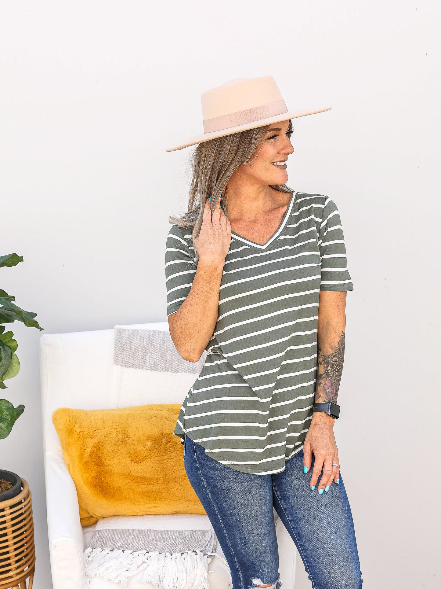 Olive green light weight v neck short sleeve  top with horizontal stripes down the front. 