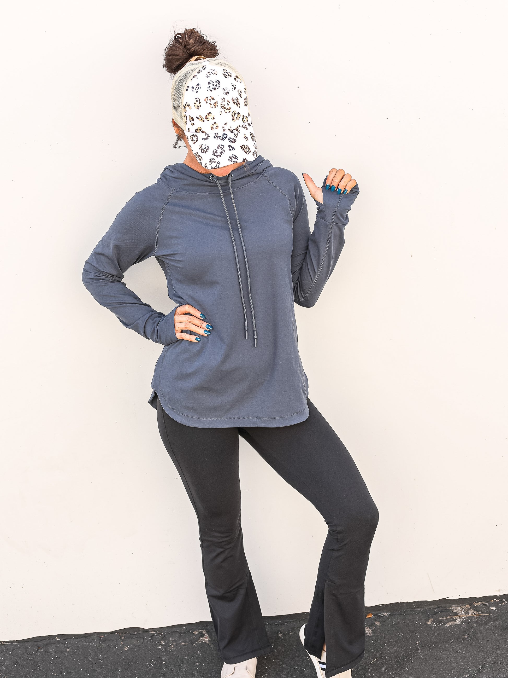 Simple blue hoodie with drawstrings and thumb hole paired for the gym with leggings and a hat