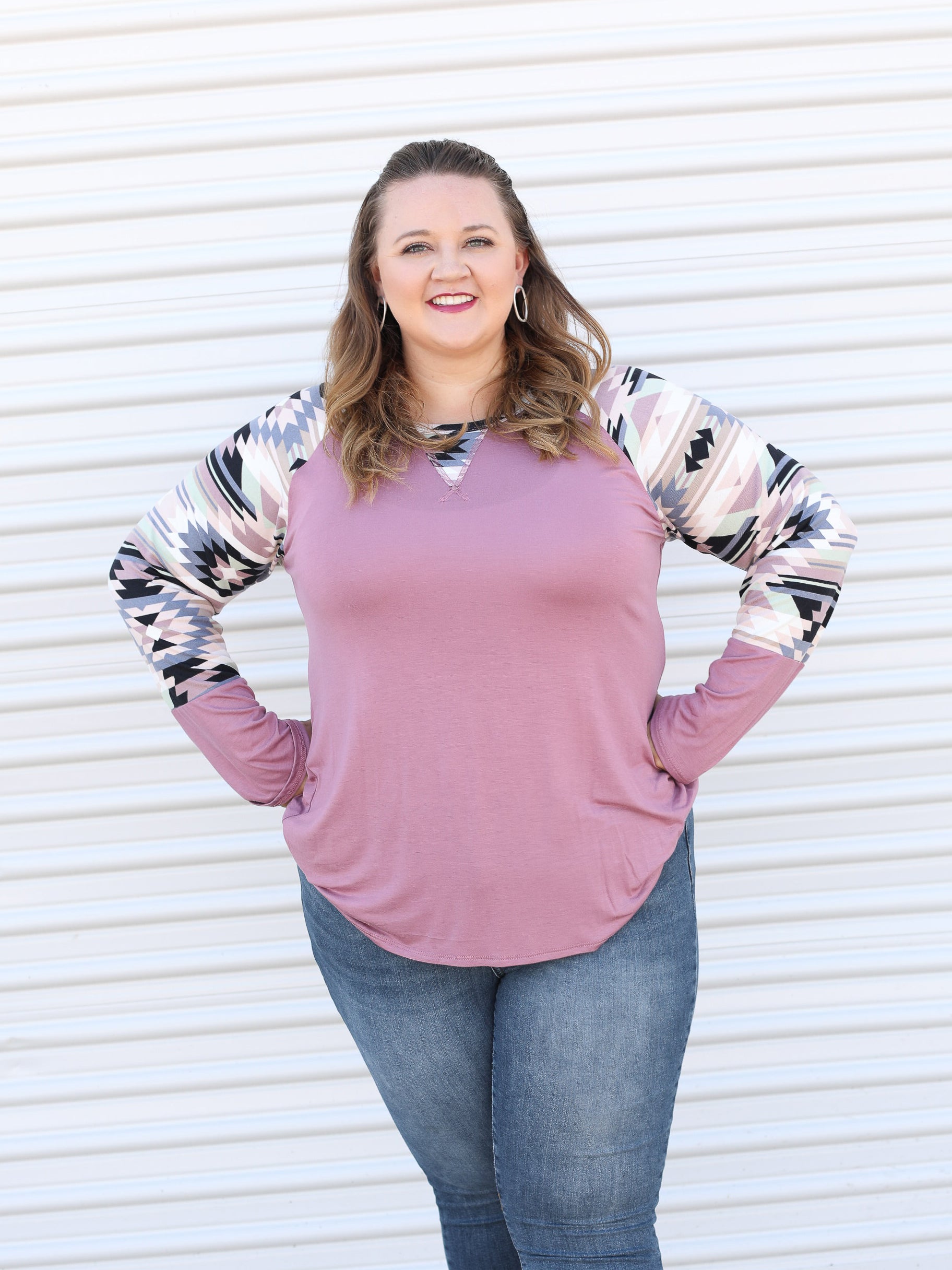 Stretchy long sleeve pink top with colorful aztec print along the sleeves