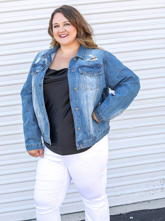 Side view denim jacket paired with black silk tank top