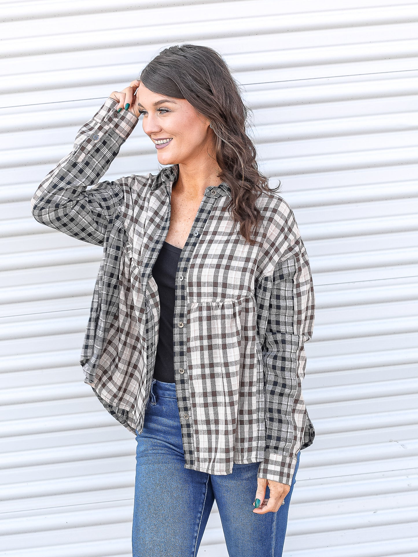 Plaid button up baby doll top paired with a tank top and jeans