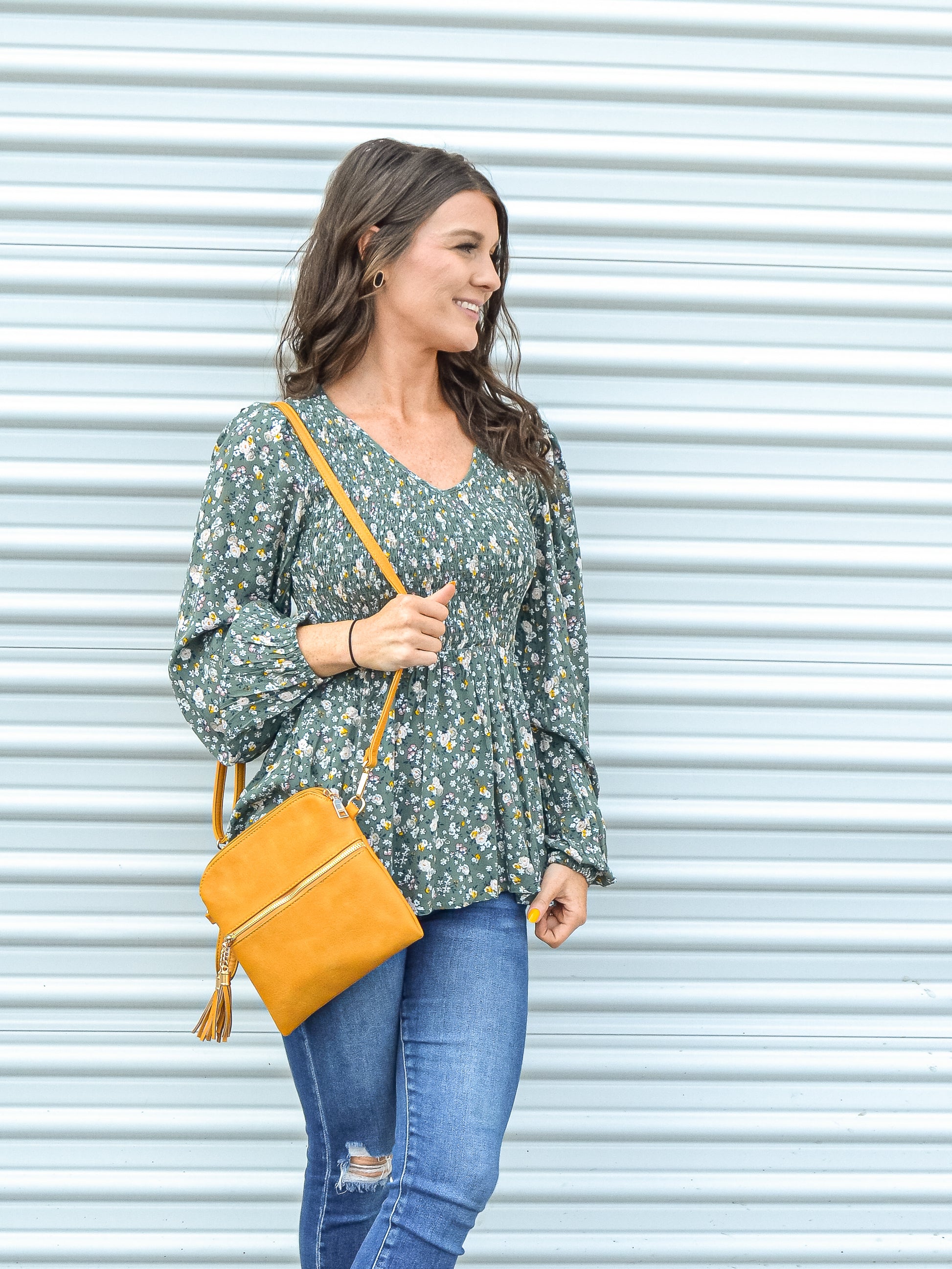 Green floral baby doll top paired with jeans and a purse