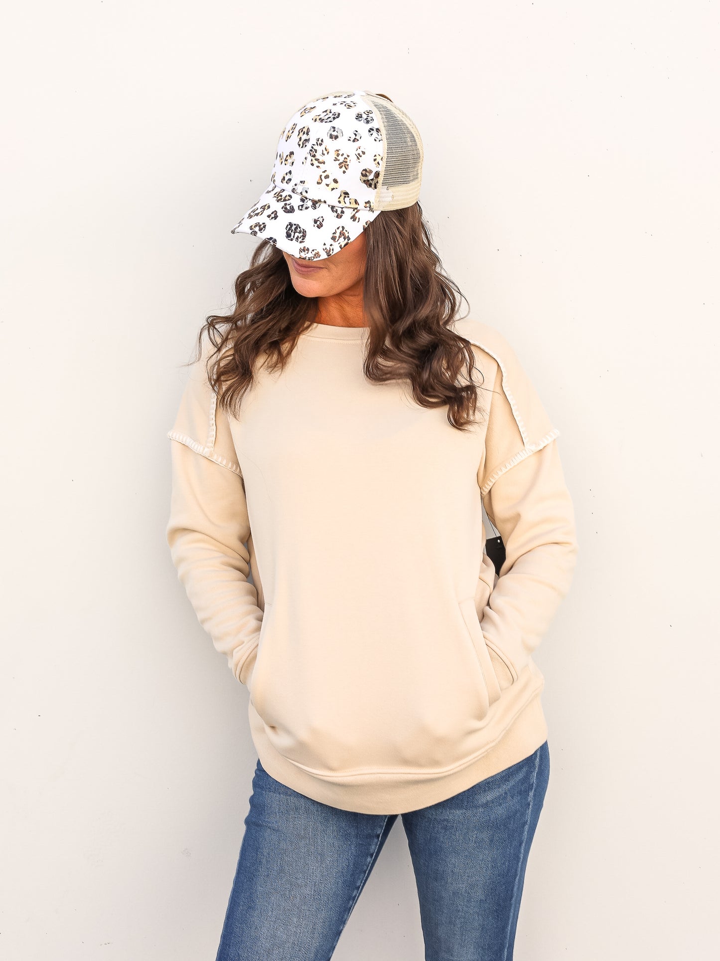Cozy cream colored crew neck sweater with a leopard hat and jeans