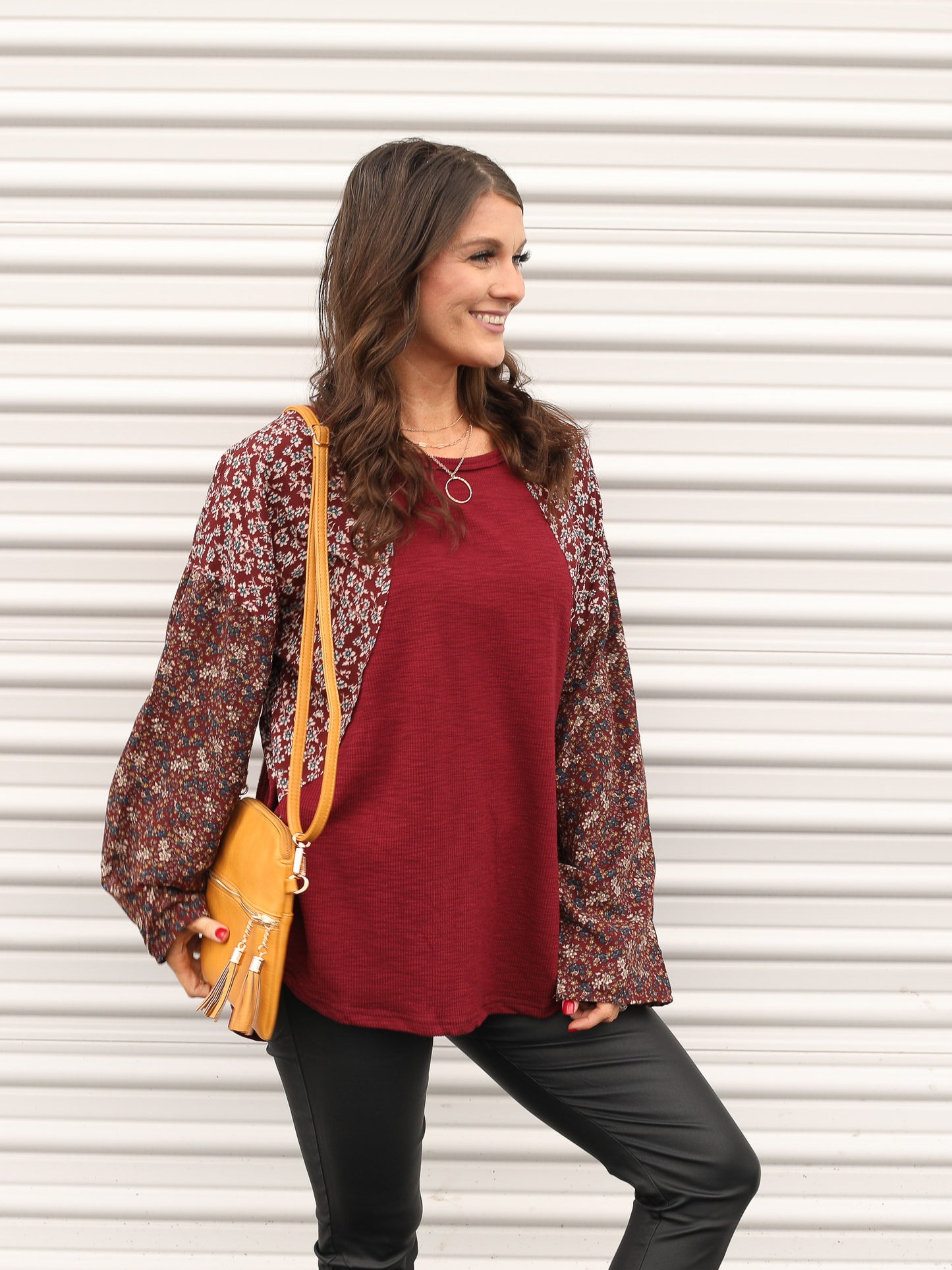 Deep red floral top styled with jeggings and a purse