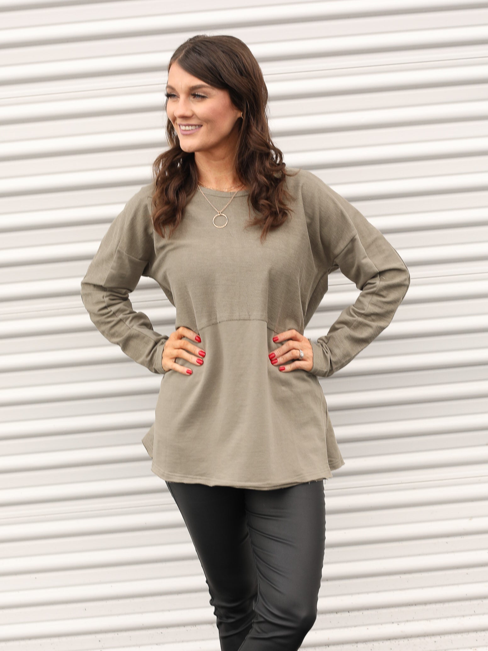 green long sleeve top paired with jeggings and simple necklace