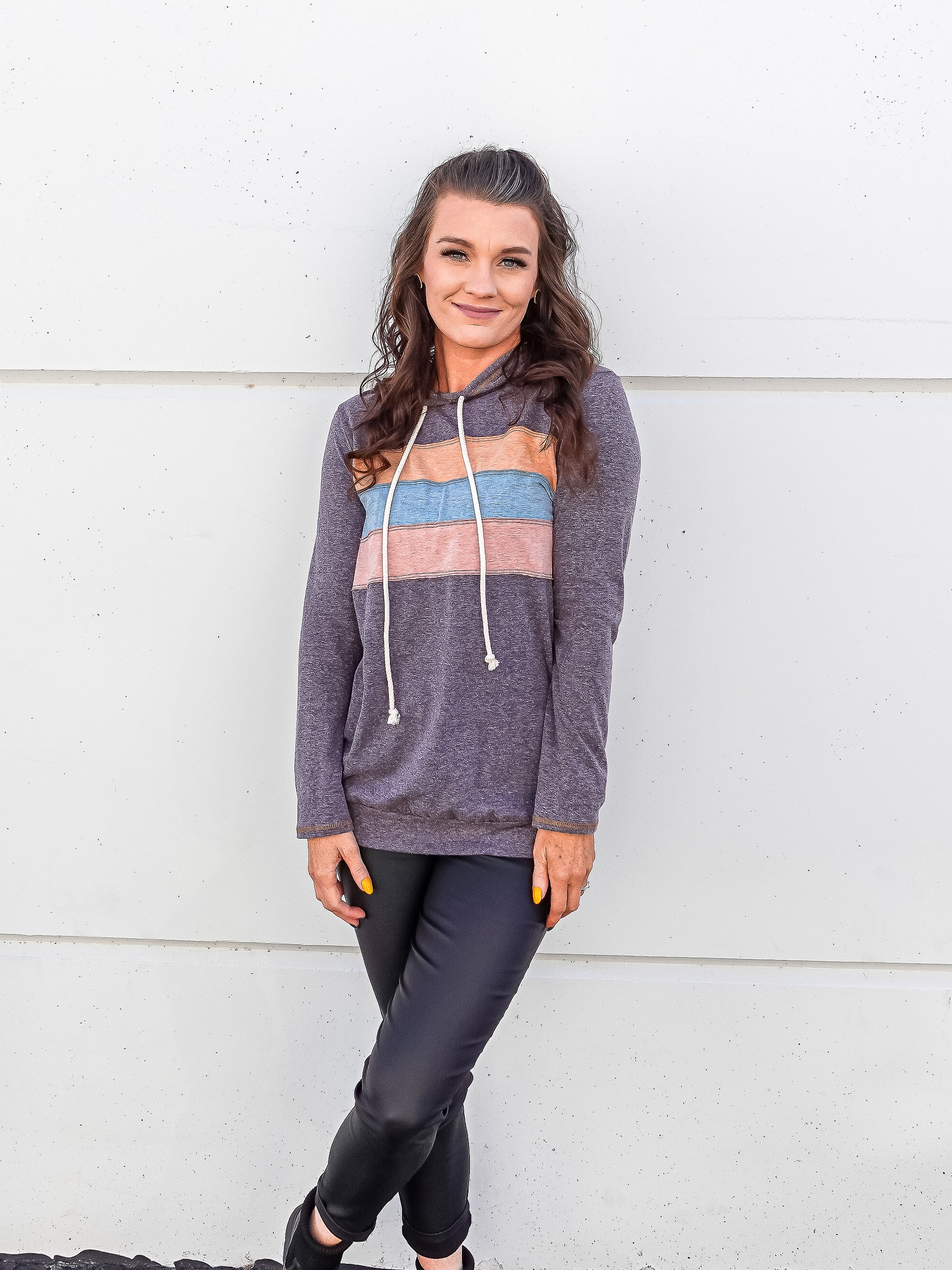 Heathered plum colored hoodie with three thick stripes across the front, orange, blue and pink.