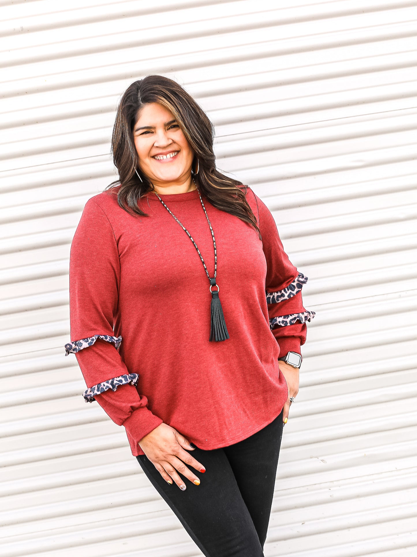 Red long sleeve top with leopard ruffled details on the lover sleeves.