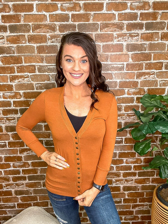 Rust colored snap button cardigan with a tank top underneath. 