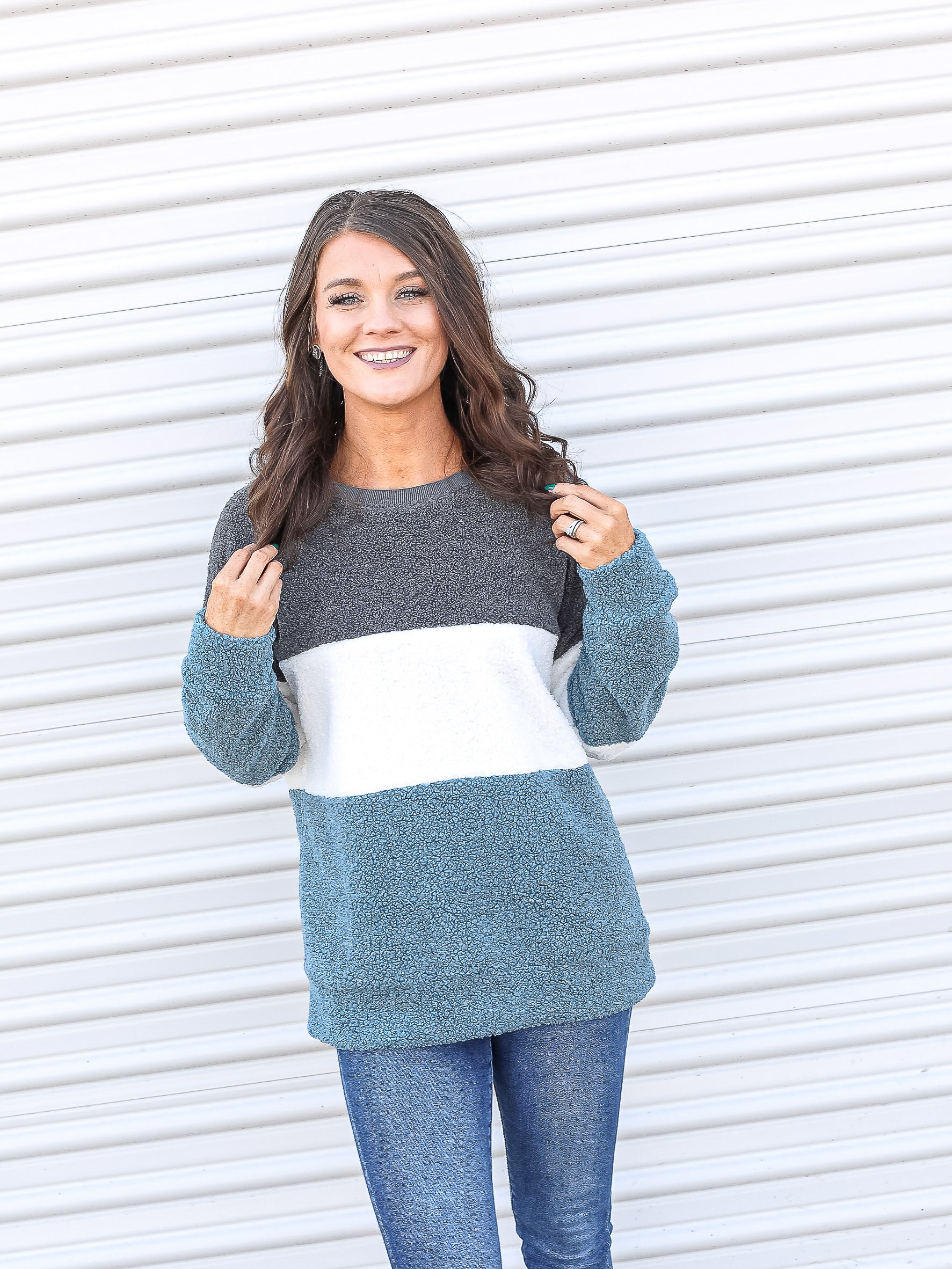Plush sweater with grey, white, and blue color blocking down the top.