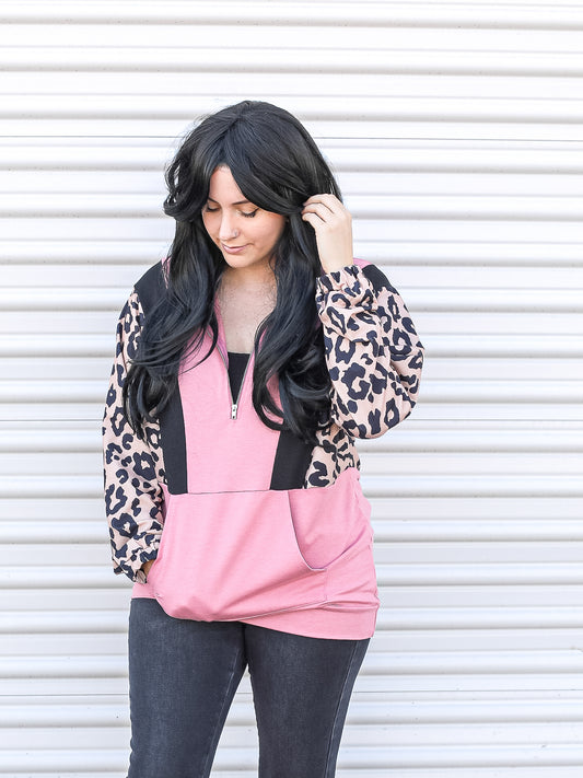 Pink half zip pull over with leopard sleeves.