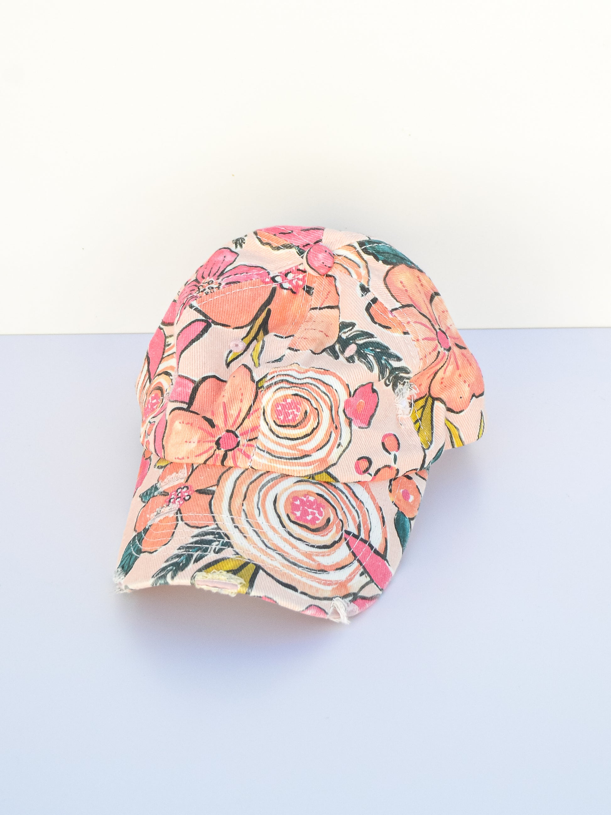 Light pink floral baseball cap with distressing.