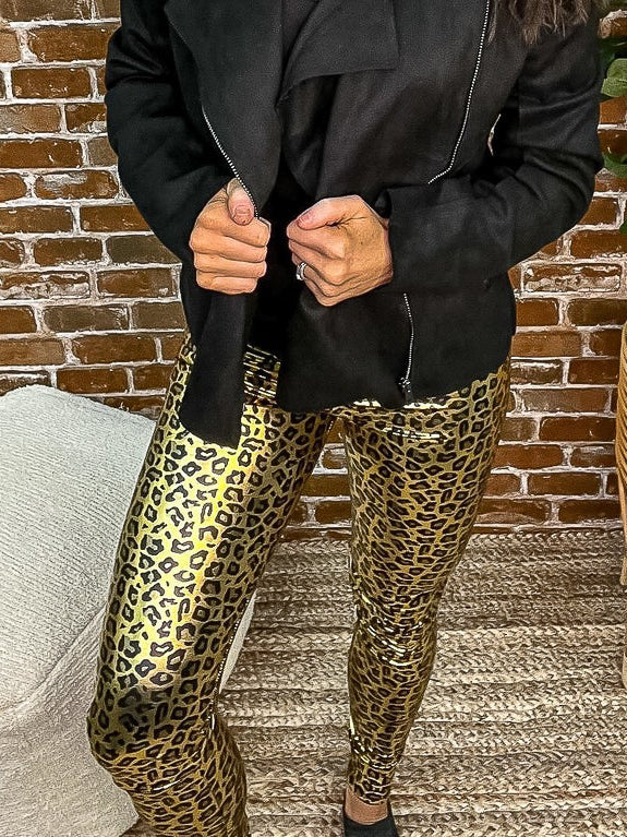 Gold shiny leopard leggings paired with a black jacket.
