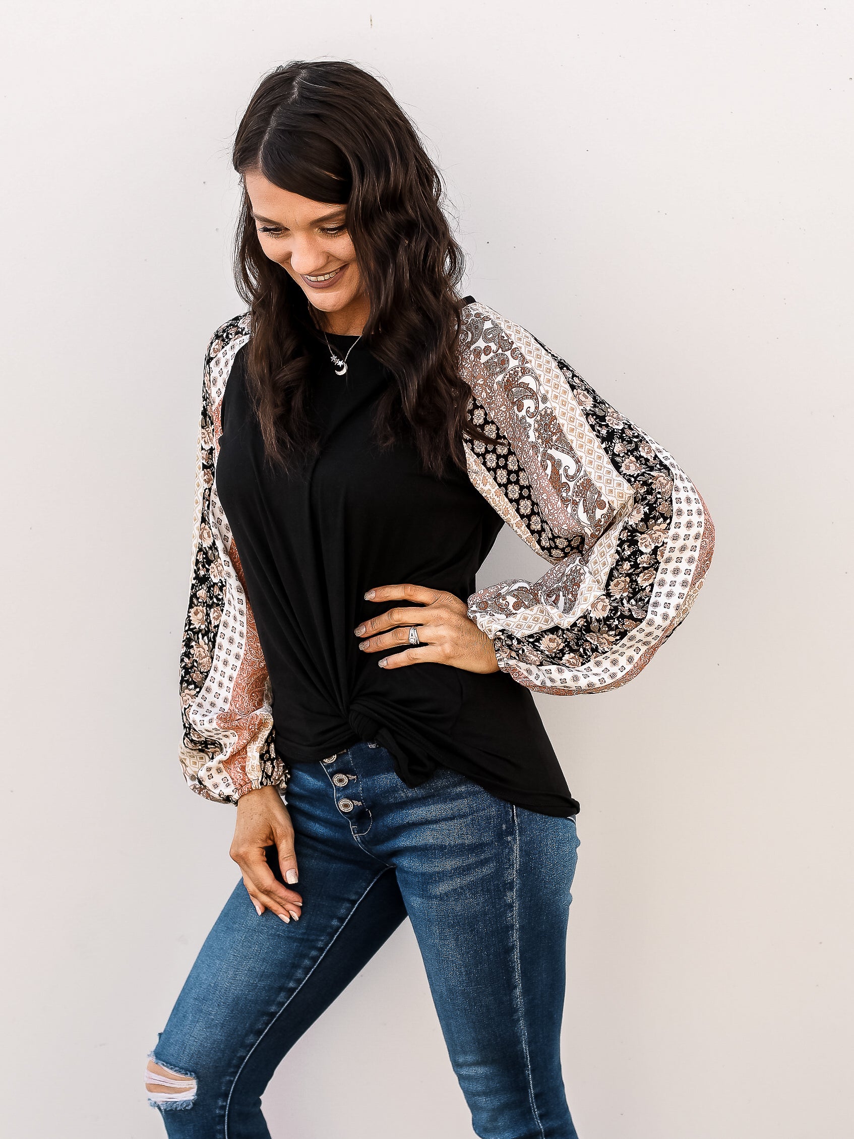 Black top with mixed patterned sleeves in floral and paisley prints.