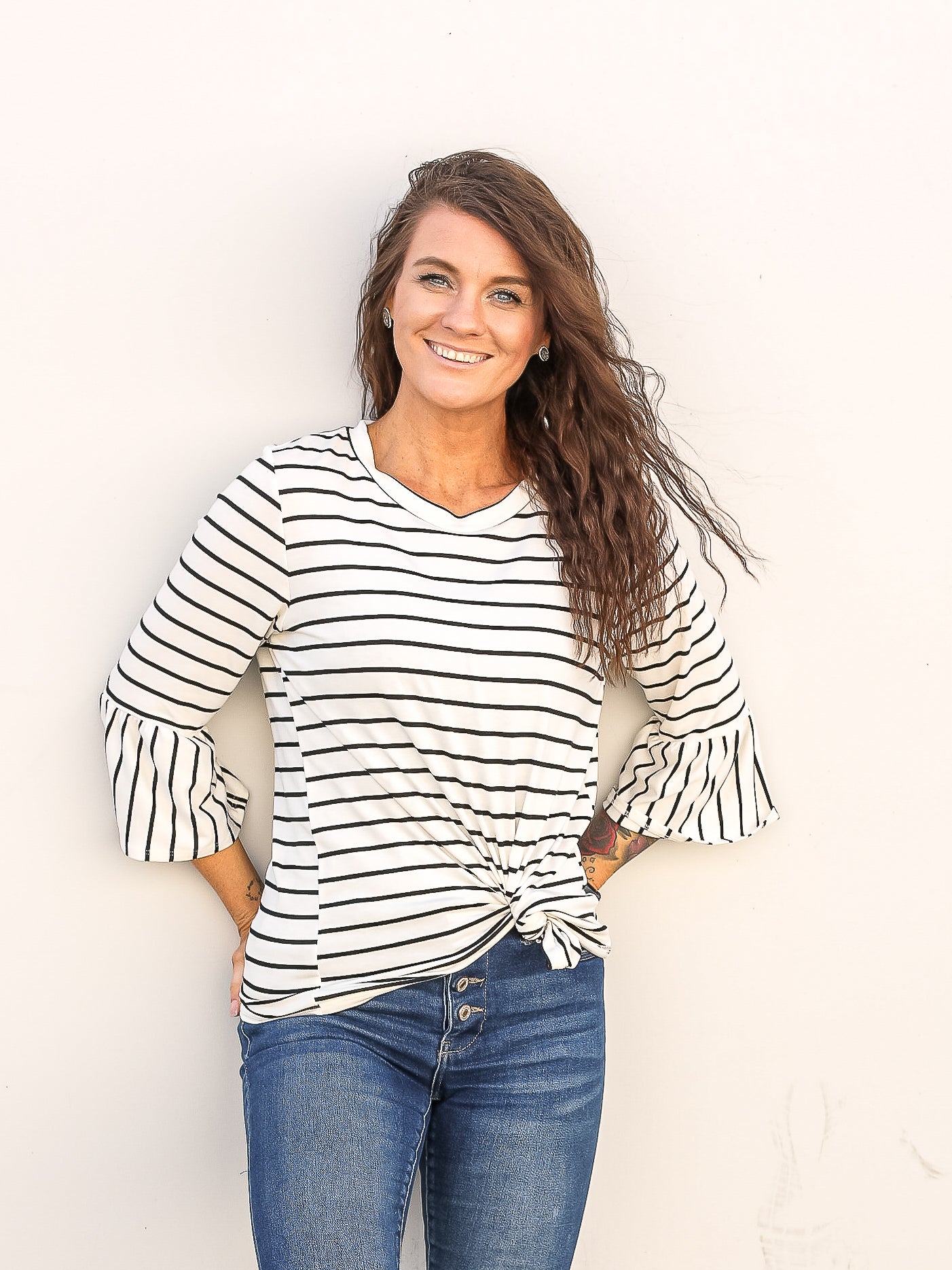Classic back and white striped top with a front knot. Styled with denim pants and stud earrings.